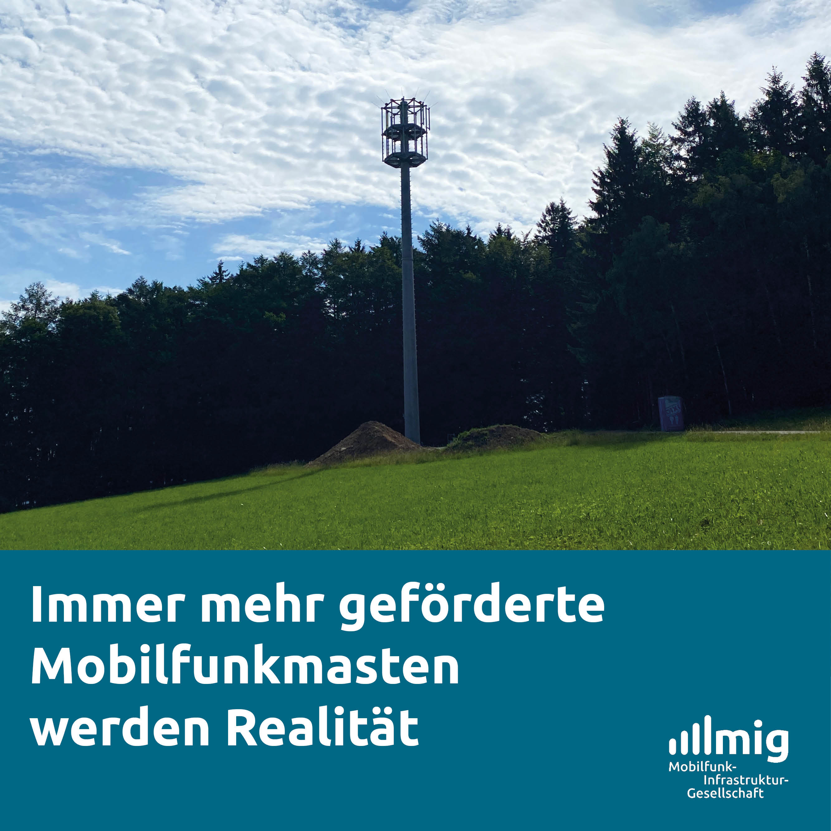 EIn Mobilfunkmast in Schleuderbetonbauweise, der an einem Waldrand steht. Der Himmel ist blau und leicht bewölkt.